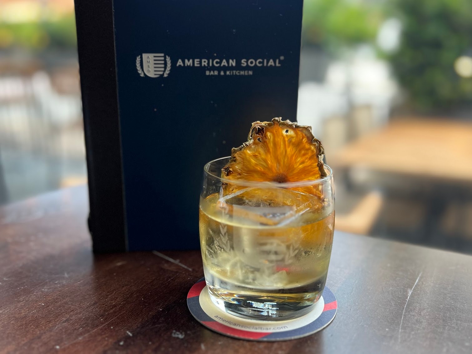 The White Lies Negroni at American Social Bar & Kitchen — Sipsmith Gin, Lillet Blanc, Heirloom Pineapple Amaro, dehydrated turbinado pineapple wheel. Photo: American Social Bar & Kitchen
